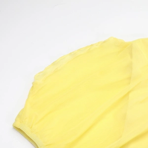 Gros plan détaillé du tissu en tulle jaune avec bordure élastique sur une robe sans manches