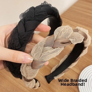 Detail view of the twisted weave texture on a wide-brimmed black and beige tulle headband