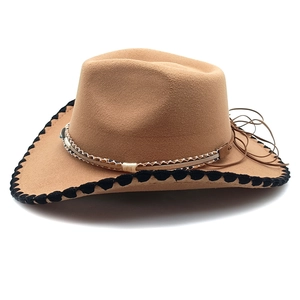 Detail of khaki felt cowboy hat featuring snake pattern band and contrast stitching edges