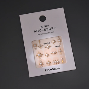 Detail of MJ-032 nail stickers featuring gold star motifs and elegant pearls on card