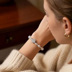 Elegant French style pearl bracelet with zircon flower pendant on a female wrist