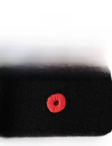 Close-up of premium red embroidered eyelet on black twill knit fabric of sports cap