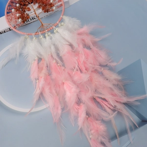 Close-up of pink dream catcher featuring a tree of life design with orange crystal stones