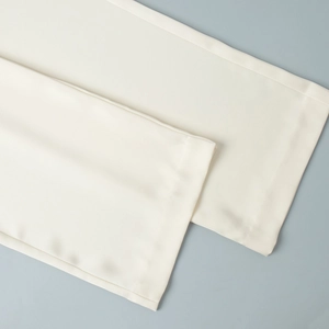 Detailed view of cream satin pants showing high-quality stitching and smooth fabric texture
