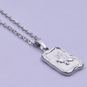 Detail shot of silver stainless steel rectangle pendant with butterfly relief design
