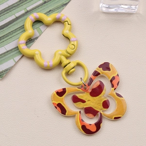 Detail of a yellow leopard print butterfly acrylic keychain with flower spring hook