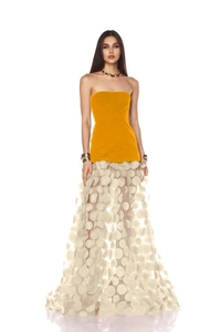 Close-up of ginger strapless dress featuring white 3D polka dot tulle skirt overlay