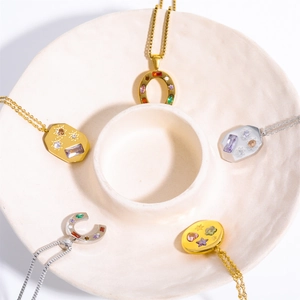 U-shaped kaleidoscope lucky symbol necklaces with colorful zircon on a beige plate
