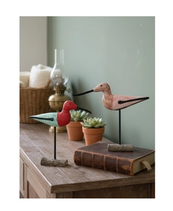 Detail of hand-painted Nordic wood birds with newspaper print wings on metal stands