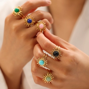 Close-up of stacked colorful turquoise sunflower rings on hand in warm lighting