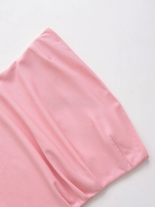 Detail view of the pink ruched fabric texture and fine stitching on a slim-fit top