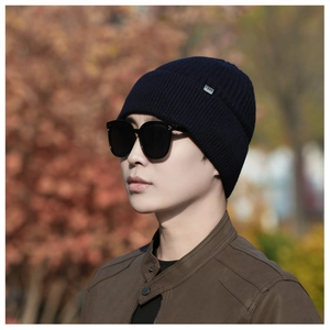 Close-up of navy blue ribbed knit beanie featuring a small metal F3KS logo plate