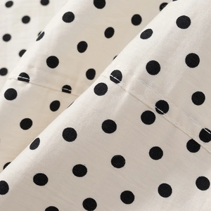 Nahaufnahme von gewebtem Polka-Dot-Stoff mit sichtbaren Nähten an Sportbekleidung