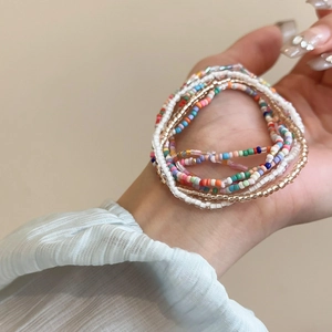 Close-up of bohemian multi-layer colorful seed bead bracelets set on a female hand