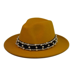Detail of yellow wool fedora hat featuring black band with layered pearl embellishments