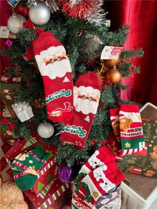 Close-up of festive Christmas socks hanging on a decorated tree with Merry Christmas text