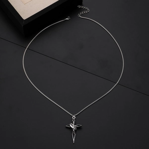 Vintage cross pendant necklace with ring detail on a black geometric background
