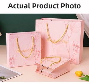 Pink gift bags with gold handles and 'Beautiful Day' text in various sizes