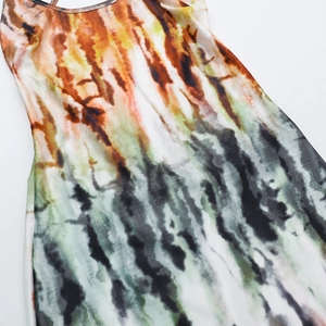 Dettaglio della trama sfumata tie-dye e spalline sottili su un abito estivo con schiena scoperta