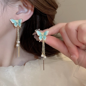 Détails des boucles d'oreilles papillon bleu avec chaînes à pompons et perles
