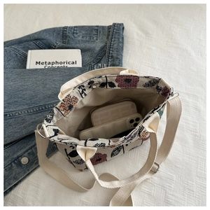 Detail view of large canvas tote bag with floral print and adjustable shoulder strap