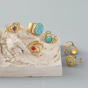 Detailed view of bohemian gold rings set with turquoise and caraway stones on stones
