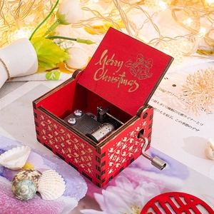 Close-up of wooden music box with Merry Christmas engraving and festive holiday ornaments