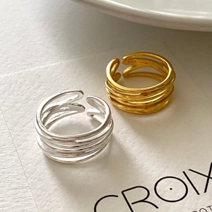 Macro shot of S925 hallmark on minimalist multi-layer silver and gold rings