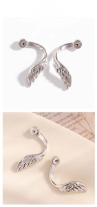 Detailed close-up of polished silver angel wing earrings with intricate feather textures