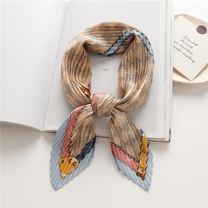 Détail de la texture plissée et du motif de chaîne géométrique élégant du foulard en soie