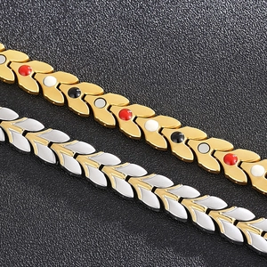 Détail de bracelets magnétiques en épi de blé or et argent avec incrustations sur fond noir