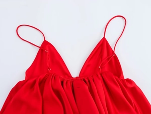 Détail du caraco en satin rouge avec décolleté en V profond et fines bretelles