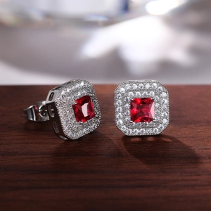 Macro shot of silver square halo earrings featuring red cubic zirconia and double border