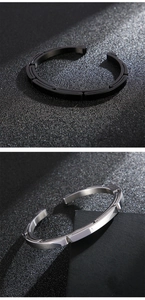 Detail of silver and matte black stainless steel open bangles with brushed texture