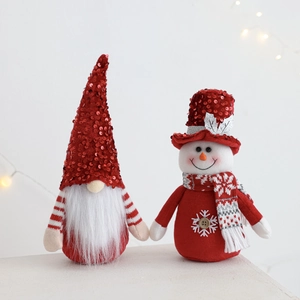 Close-up of plush Christmas gnome and snowman dolls with red sequins and soft white fabric