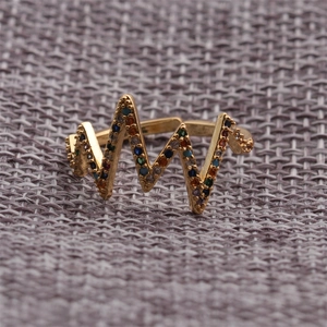 Macro detail of wave-shaped golden ring with multi-color zircon stones and open band