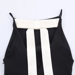 Detail of black top featuring a large white satin bow on the back with thin straps