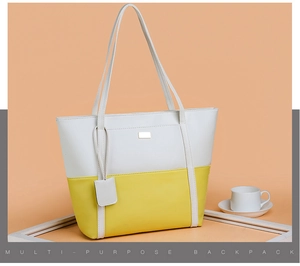Detail of a white and yellow PU leather tote bag featuring a small metal logo and dual straps