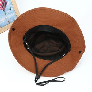 Detailed interior of a caramel canvas sun hat featuring black sweatband and windproof cord