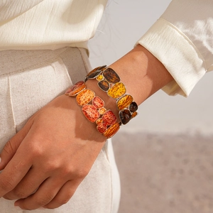 Detail view of retro stretch bracelet featuring warm amber resin and hammered texture