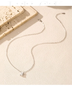 Macro shot of silver Moissanite square pendant on a fine chain over stone props