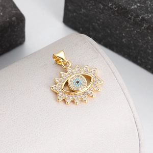 Macro view of gold sunburst evil eye pendant with turquoise stones and zircons