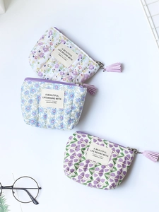 Three floral cotton coin purses with tassels and zipper closures in various patterns