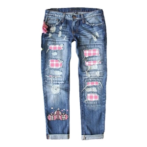 Jean bleu à taille mi-haute avec trous déchirés et empiècements à carreaux roses