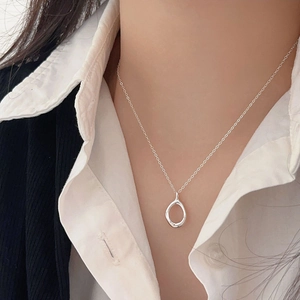 Detail view of a minimalist 925 silver hollow water drop pendant necklace on a model