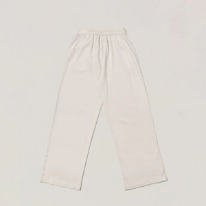 Detail of loose-fit off-white sweatpants featuring ribbed texture and elastic waistband