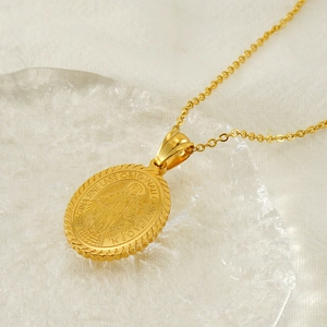 Vintage gold oval Virgin Mary pendant necklace in stainless steel on ice prop