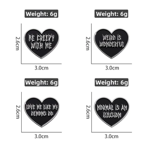Detailed view of four gothic black heart enamel pins with unique creepy English phrases