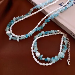 Aquamarin und Perle Doppelarmband Halskette Set auf braunem strukturiertem Hintergrund