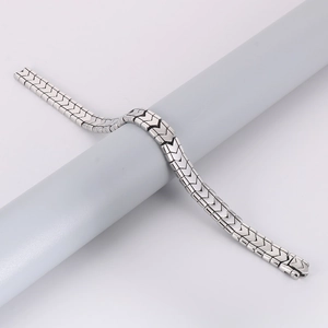 Detailed view of silver stainless steel curb chain bracelet with V-shaped arrow patterns